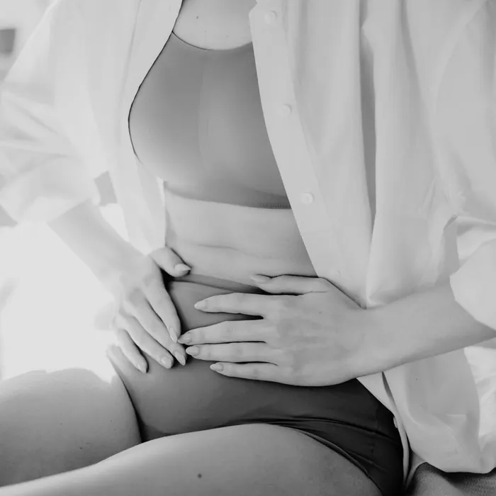 Une femme tient son bas-ventre à deux mains