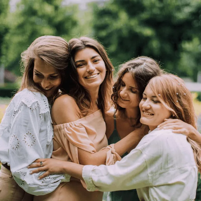 Un groupe de femmes rient, serrées les unes contre les autres